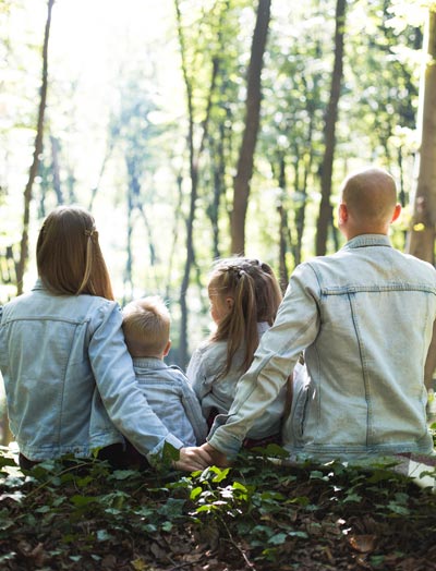 Family sitting in sunlit woods