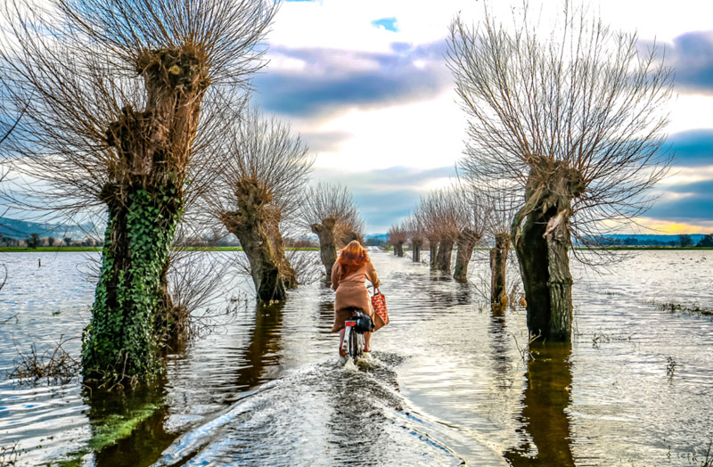 Woman cycling through floods