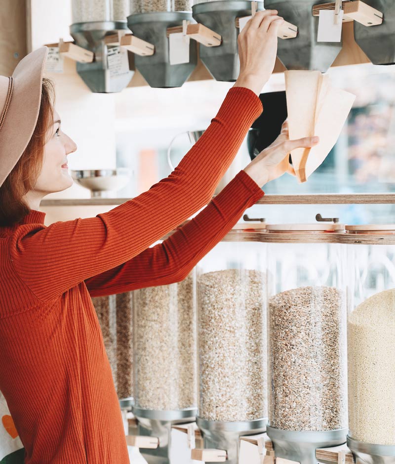 Woman using refill containers in a shop