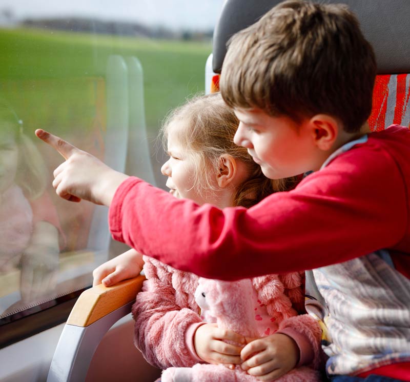 Kids on a train looking out of the window.