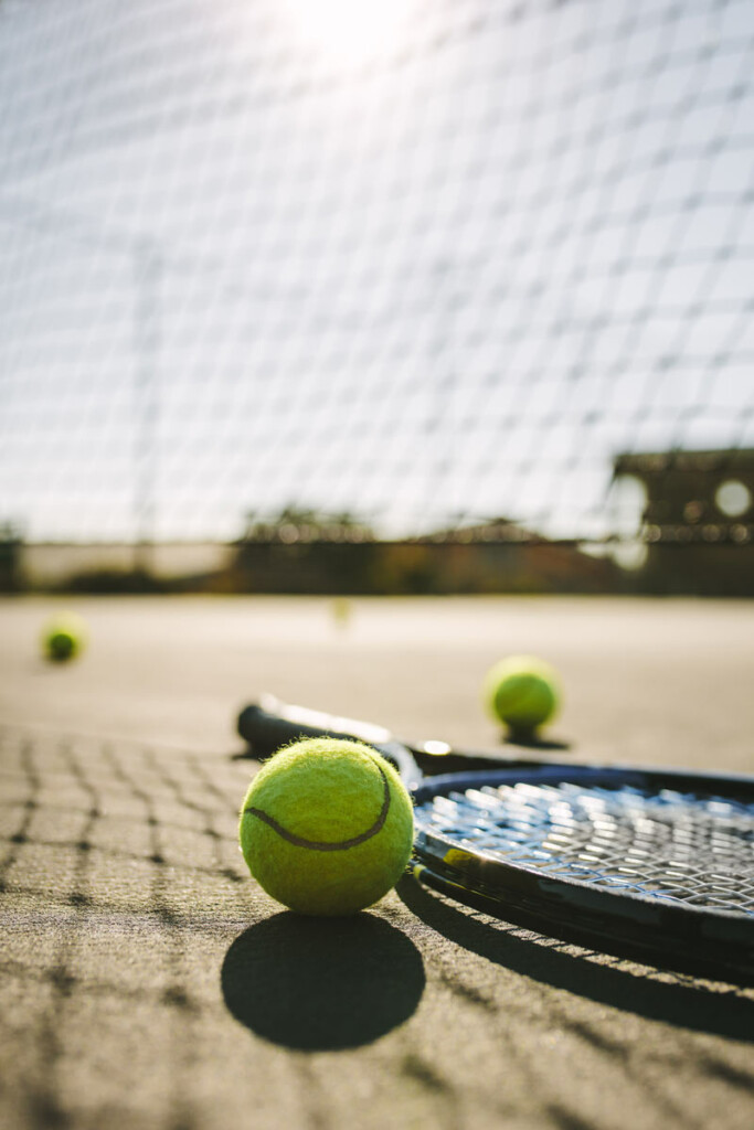Tennis racket and balls on court